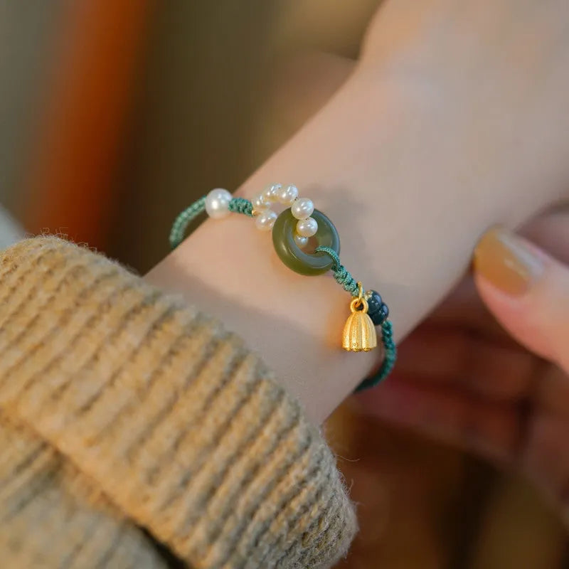 Hand-woven women's watch band with a pearl peace buckle closure on a flexible wire bracelet.