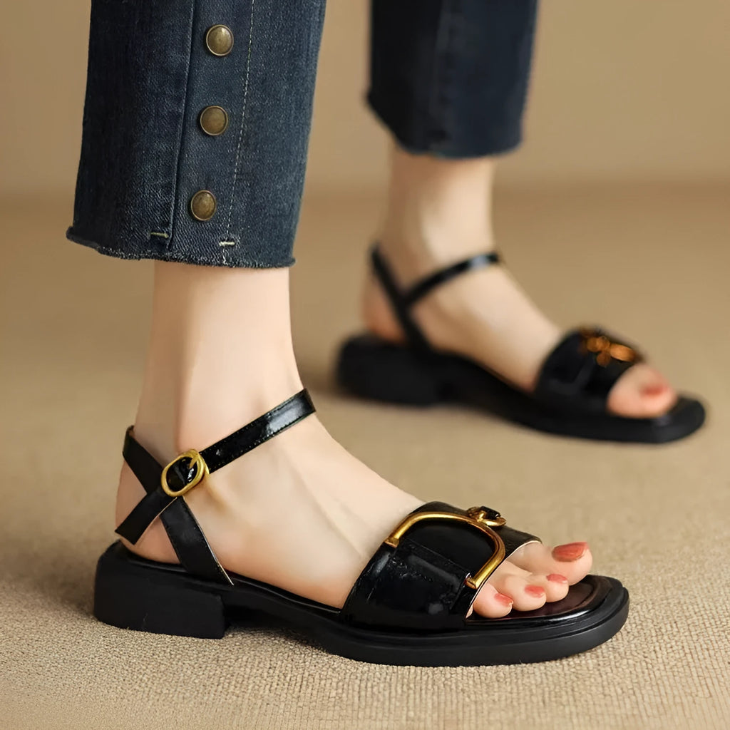 Women's beige leather sandals with a thick rubber sole and a single button closure on the strap.