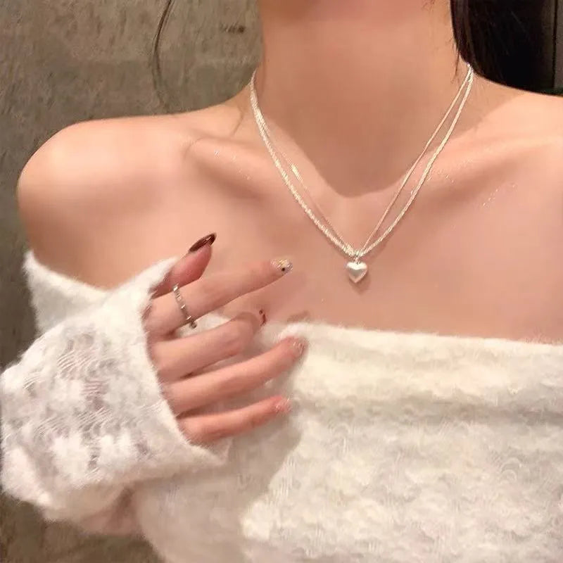 Women's double-layer brushed heart pendant necklace on a regular chain, silver tone.