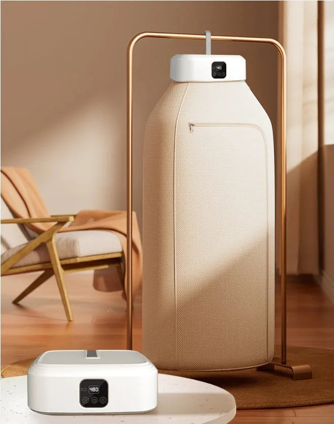 White cylindrical foldable portable clothes dryer with remote control on wooden surface