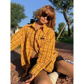 A loose-fitting dopamine yellow plaid shirt with a cardigan style, shown on a hanger.