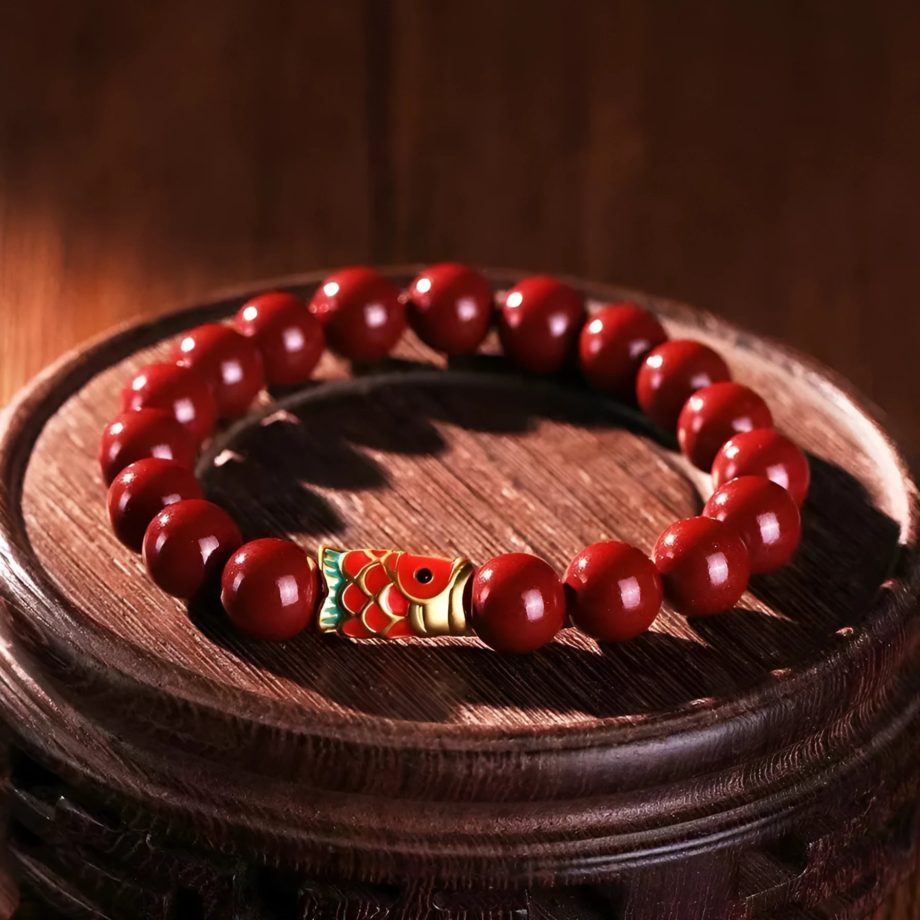 Natural cinnabar koi bracelet with golden balls in national style, showing sand grain texture