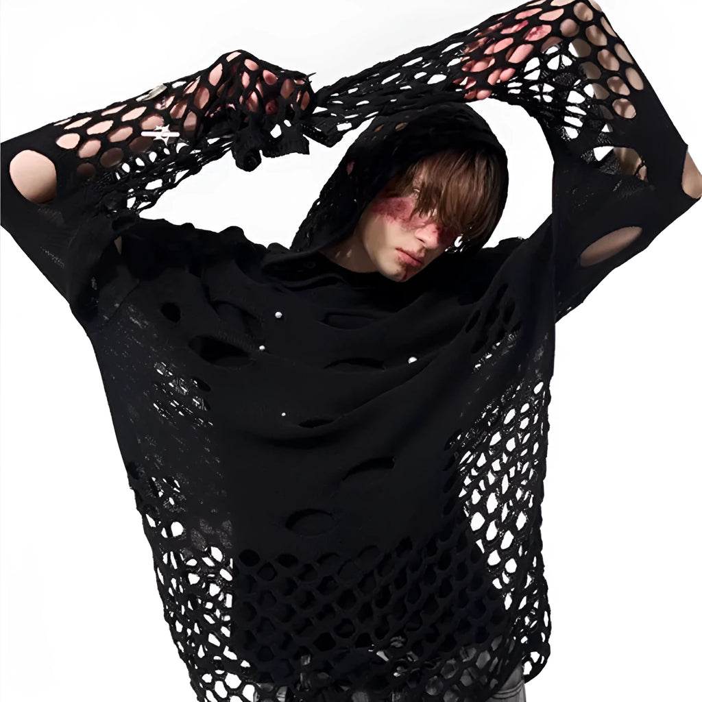 Man wearing a loose black hoodie with a pearl decoration on the front of the hood.