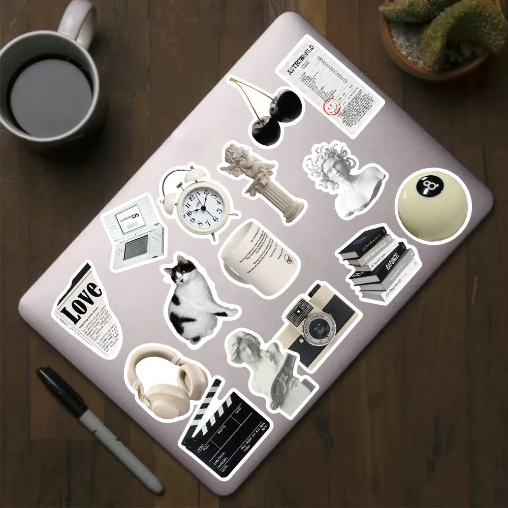 Assortment of black and white vinyl stickers featuring coffee cups and abstract designs for laptops and phones.