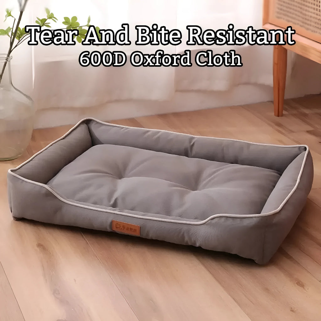 Grey waterproof dog sofa bed with raised edges, shown in a living room setting.