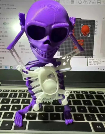 3D printed dancing skeleton gravity toy in pink and white, 22cm tall, on a desk