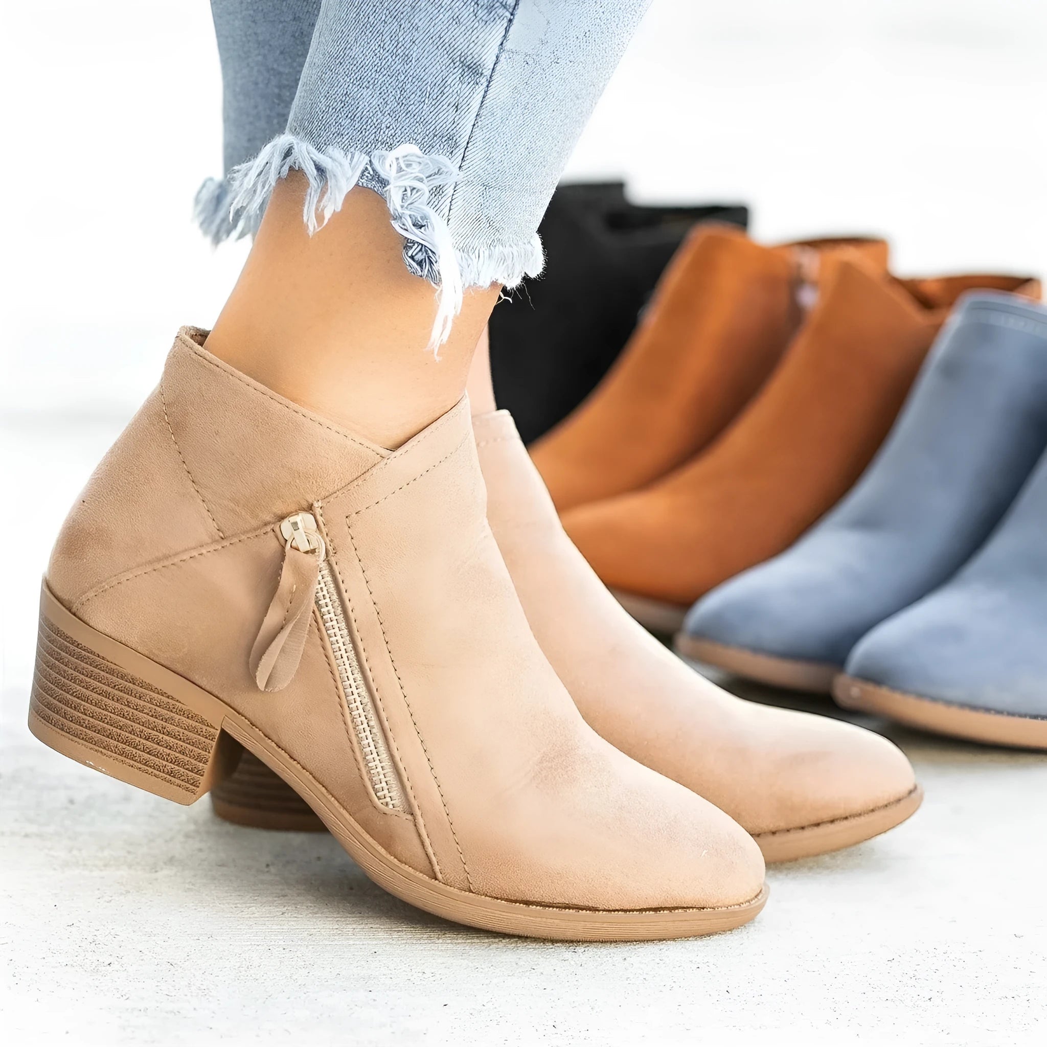 Women's blue suede ankle boots with a chunky heel and a side zip closure on a white background.
