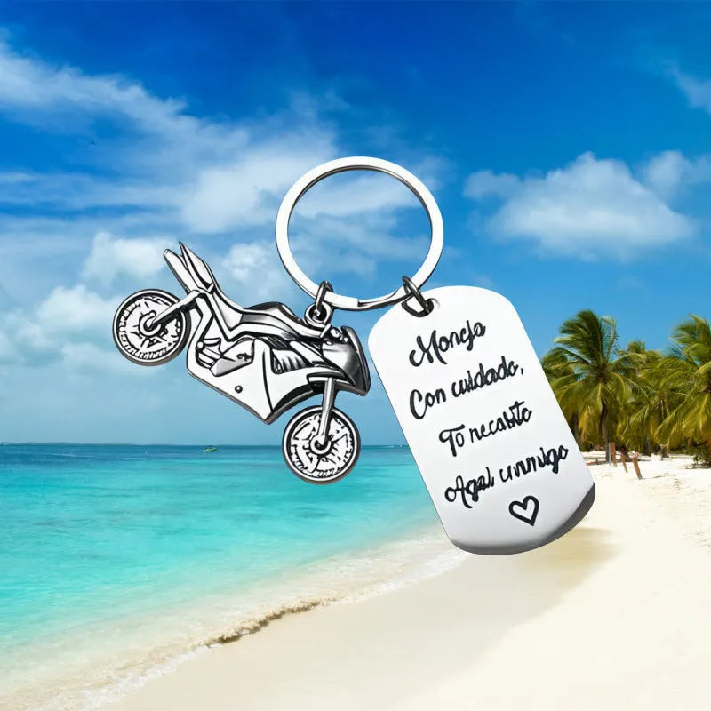 Stainless steel motorcycle keychain with inspirational design, shown with its included flannel storage bag.