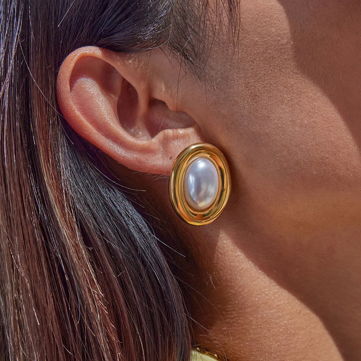 A pair of stainless steel vintage pearl stud earrings with a silver-tone electroplated finish.