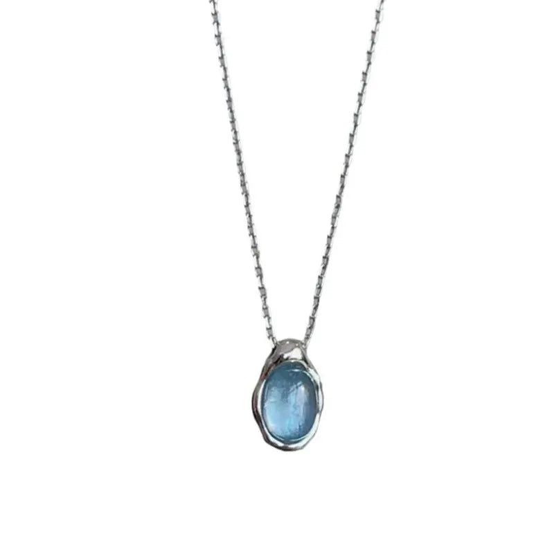 Close-up of a navy blue and platinum coloured geometric water drop pendant necklace on an adjustable copper chain.