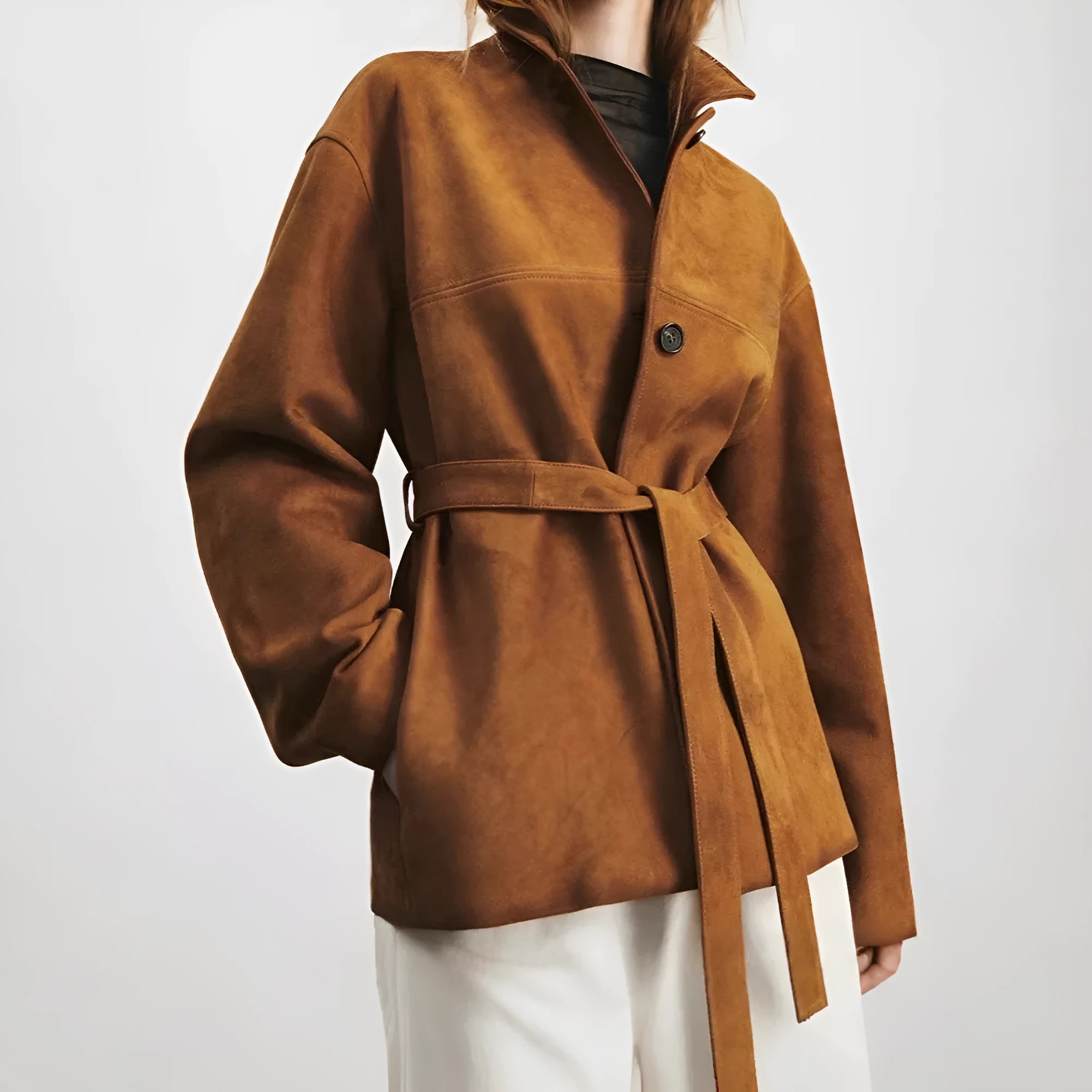 Yellow brown women's mid-length cashmere coat with Peter Pan collar and leather belt on a hanger.