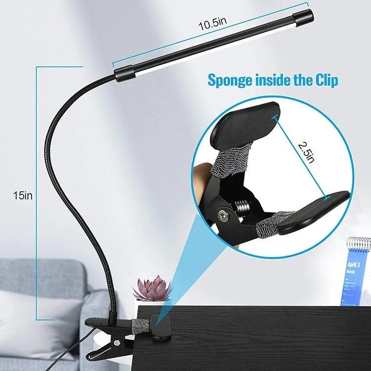 Black and white USB-powered LED desk lamp with a 26 cm long adjustable gooseneck neck on a table.