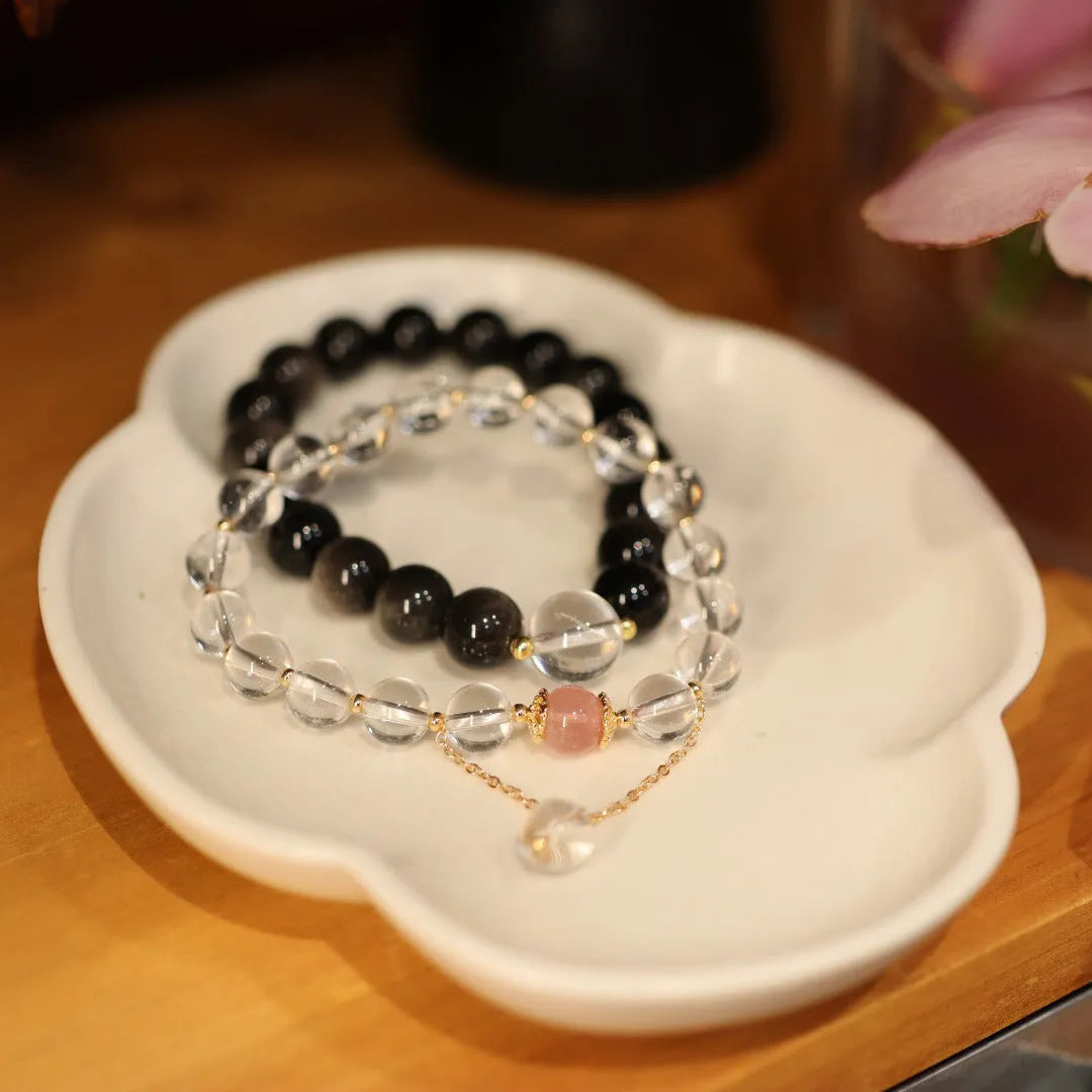 Chinese style geometric crystal bracelet with cat eye obsidian effect and auspicious patterns.