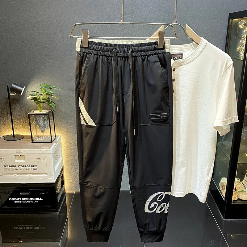 Man wearing solid black cropped cotton trousers with an ankle band.