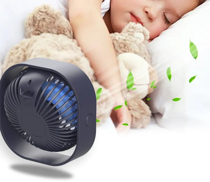 Blue USB desk fan with alarm clock display and plastic blades on a white desk.