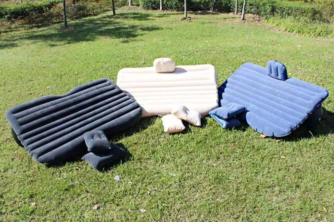 Black inflated car bed with flocked surface and two pillows inside a five-seater vehicle.