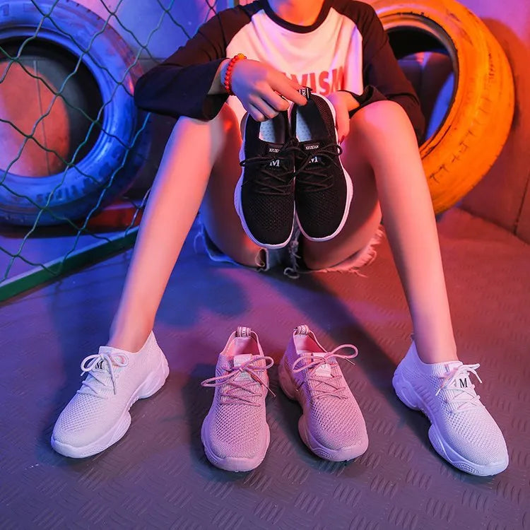 Women's white thick-soled woven sports shoes with front strap on a light background.
