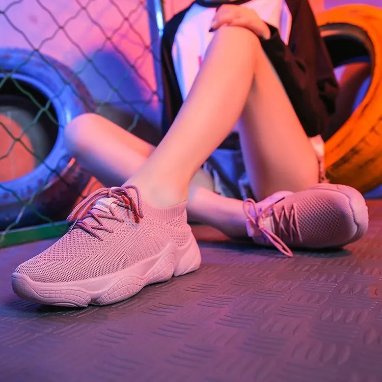 Women's white thick-soled woven sports shoes with front strap on a light background.
