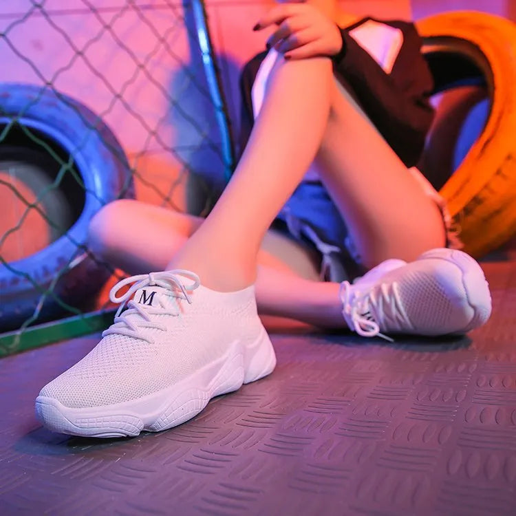 Women's white thick-soled woven sports shoes with front strap on a light background.