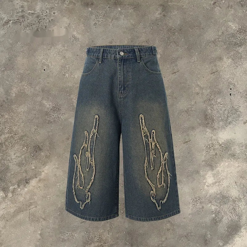 Men's black cropped denim shorts with patch flame embroidery on leg