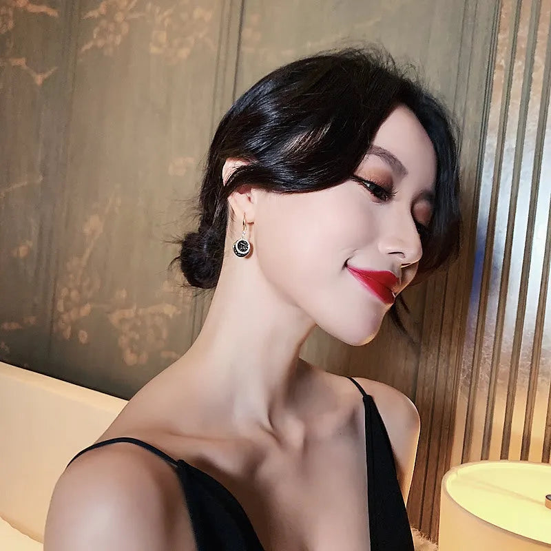 Black geometric alloy earrings with round piece shape measuring 3.6cm in length.