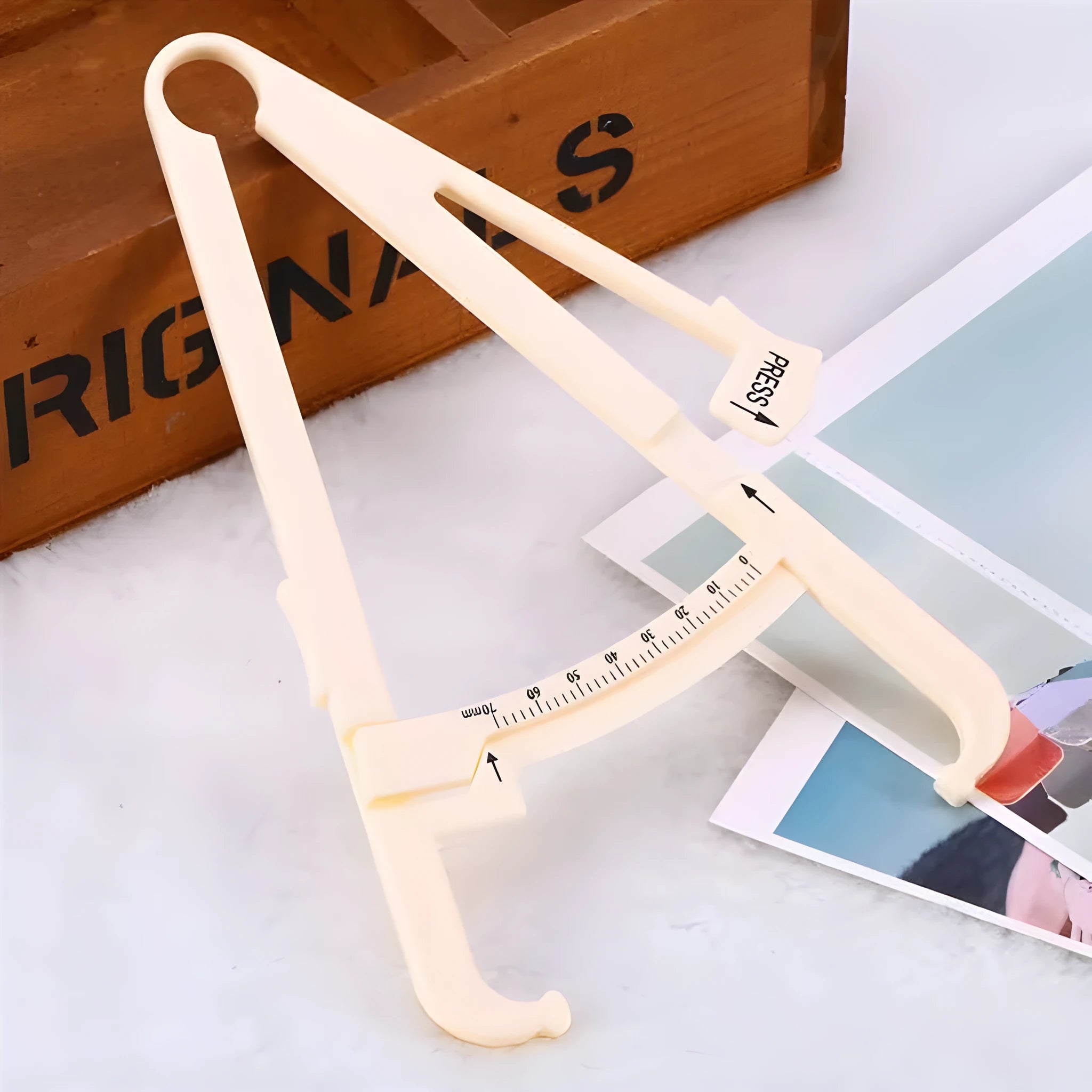 Transparent acrylic body fat caliper showing measurement scale up to 200mm