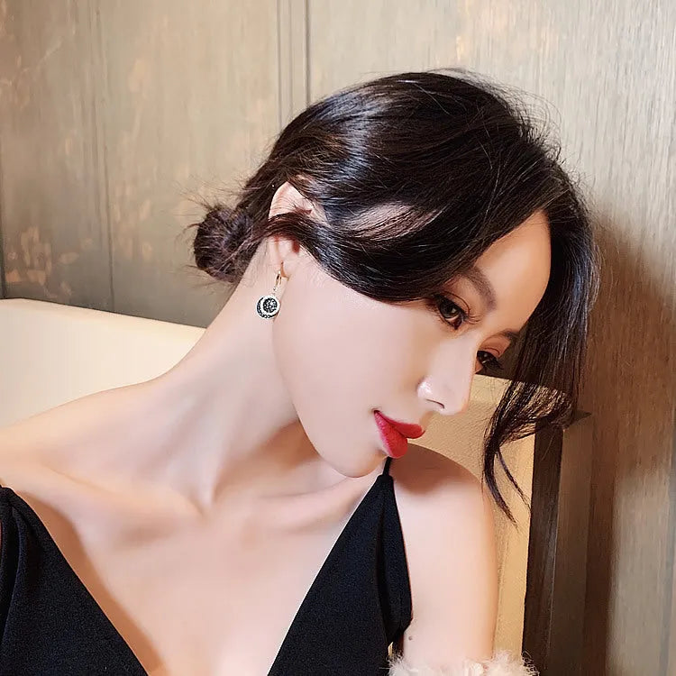 Black geometric alloy earrings with round piece shape measuring 3.6cm in length.