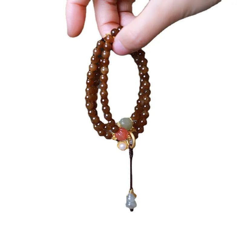 Brown Hetian jade bracelet with three-ring design featuring carved gourd and butterfly charms, silver-plated connectors