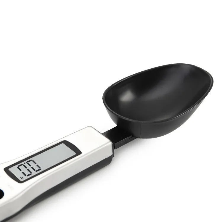 Smart digital measuring spoon with LCD display showing weight, used as a kitchen scale for food ingredients.