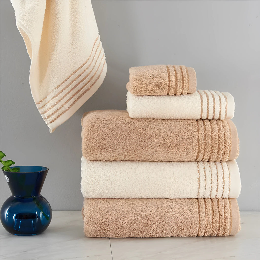 Beige and brown cotton bath towel set showing large bath towel, hand towel, and small face cloth.