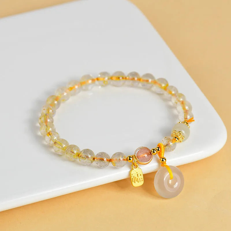 Gold rutilated quartz crystal bracelet with safety buckle closure and geometric pendant