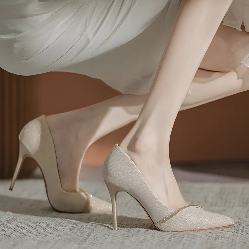 Gold and black women's stiletto pointed toe high heels on a white background.