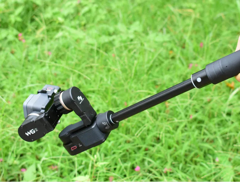 Retractable aluminium selfie stick extended to 1 metre with phone attached and Bluetooth remote in hand