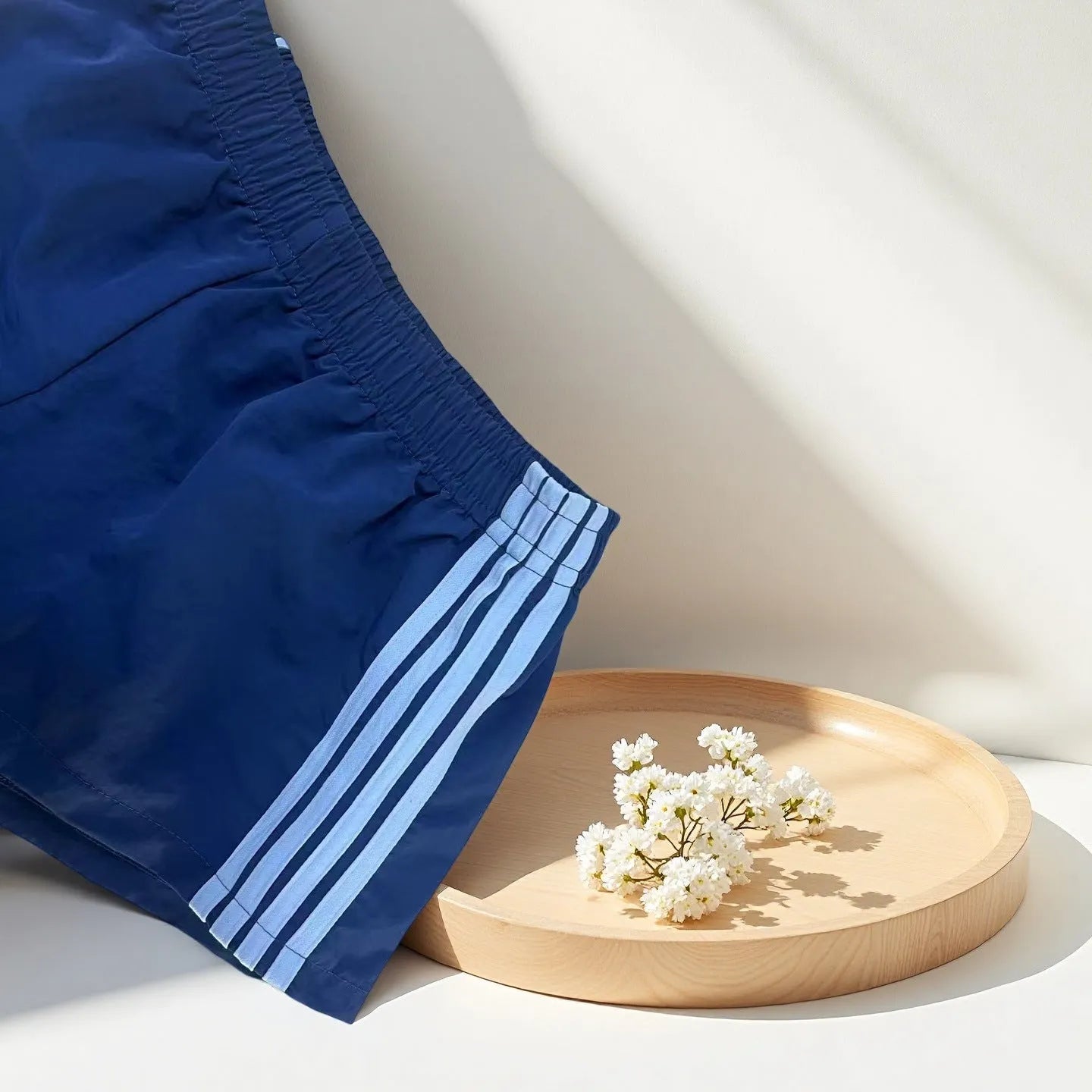 Men's navy blue high-waist nylon sports shorts laid flat, showing casual style and micro-elastic fabric.
