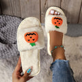 Yellow Halloween pumpkin cartoon design plush slippers with synthetic fur and a light-coloured sole.