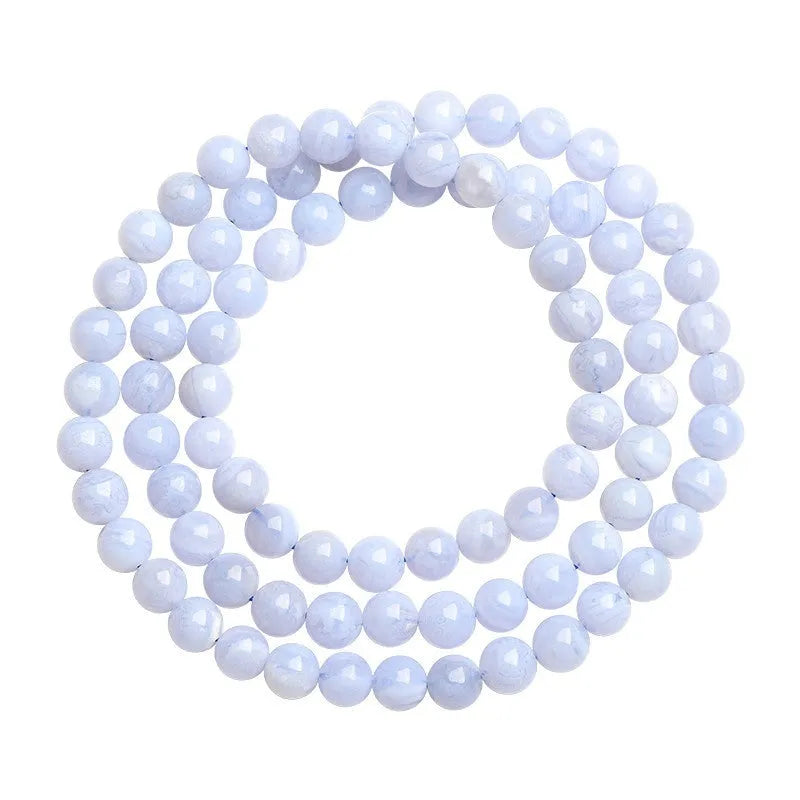 Natural blue agate bracelet showing scattered beads with blue striped pattern and three-circle design