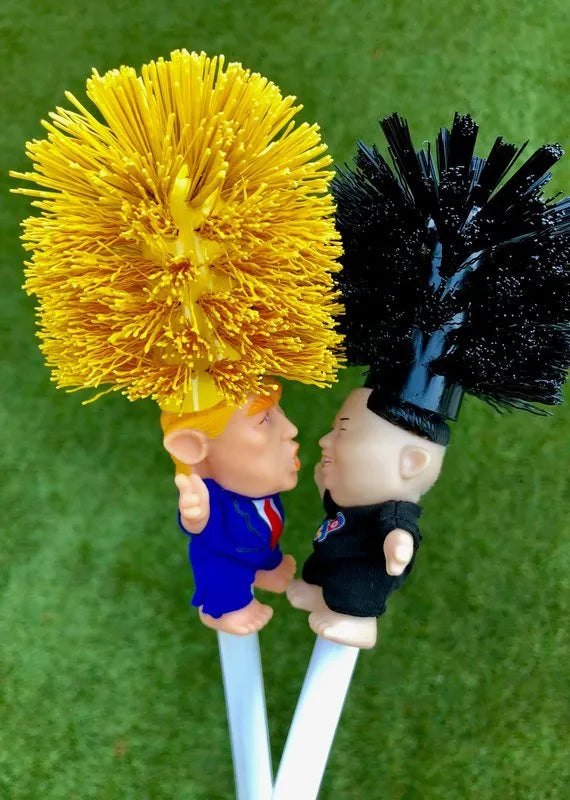 Yellow plastic Donald Trump novelty toilet brush with hanging slot.