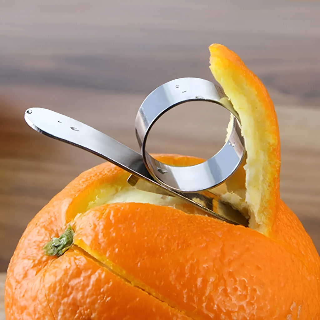 Silver stainless steel finger ring fruit peeler for citrus and pomegranates.