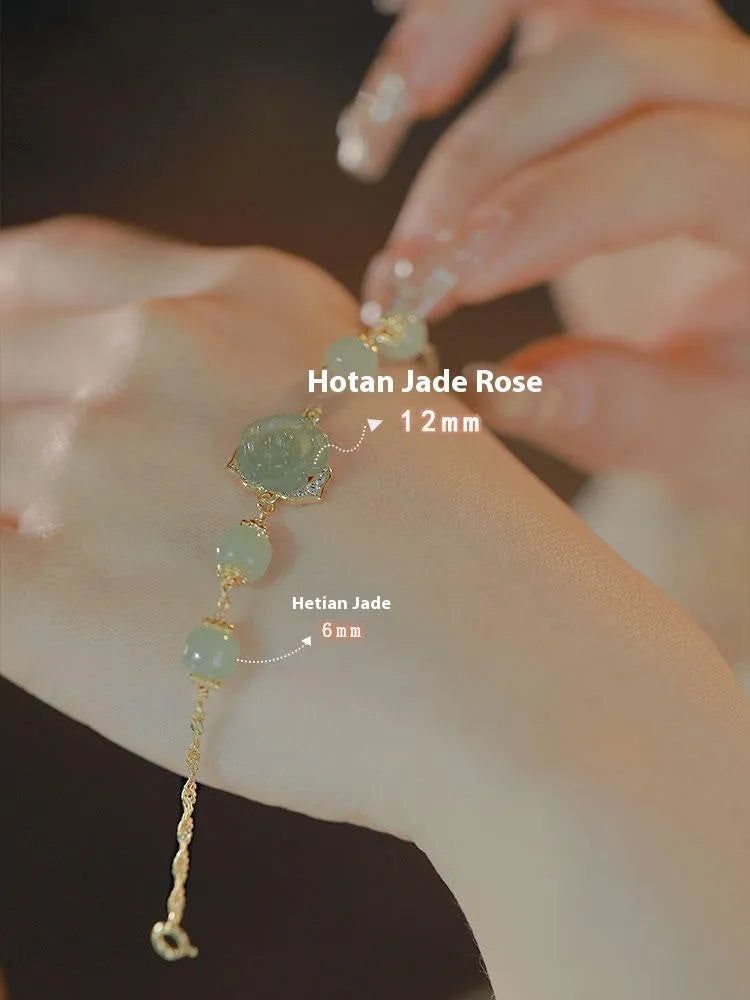 Close-up of a women's Hetian Jade bracelet with rose design and 14K gold gilding.