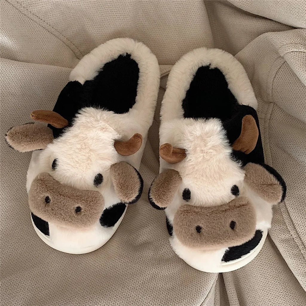 White cow print faux fur slippers for women with a non-slip textured sole.