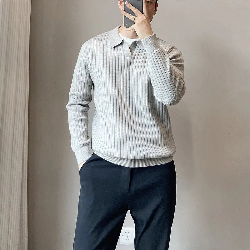 Man wearing a loose grey striped knit sweater with a lapel, long sleeves, and textured fabric.