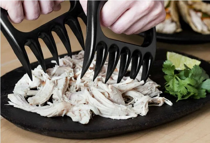 Two black bear claw meat shredder forks with paw patterns for barbecue meat preparation