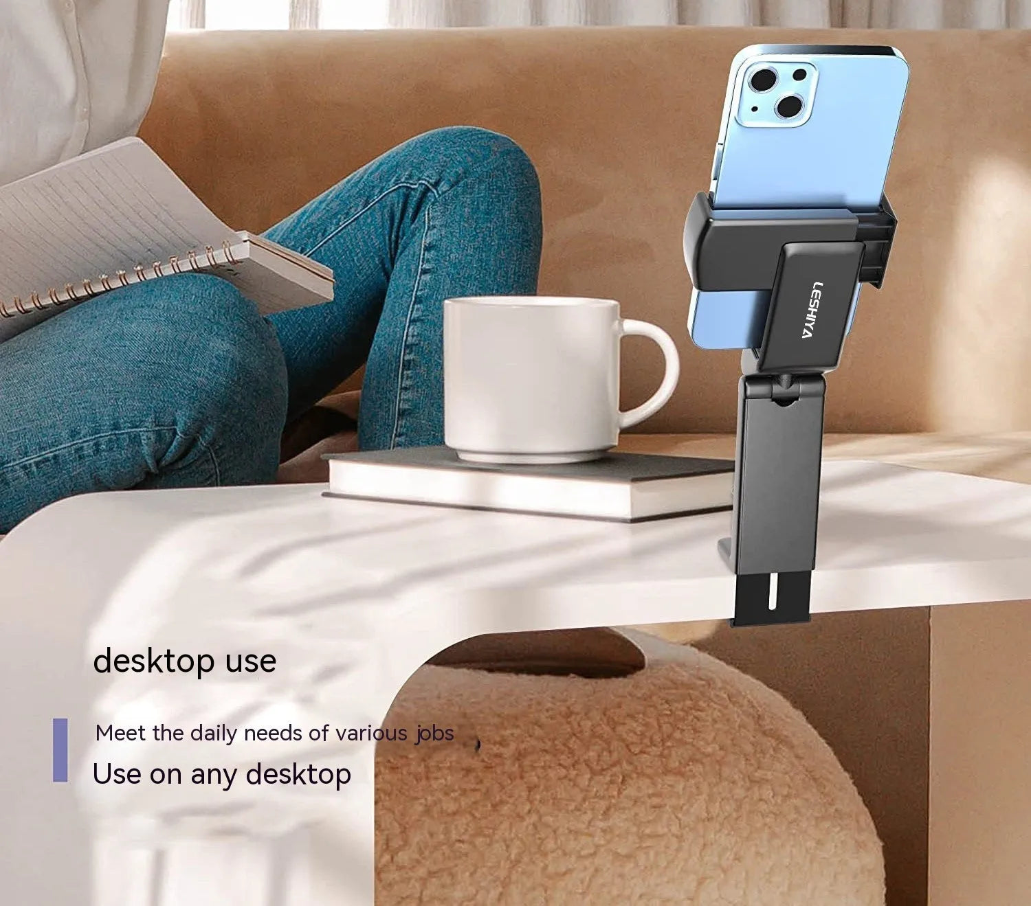 Foldable rotating phone holder in black, shown in use with a mobile phone on a desk