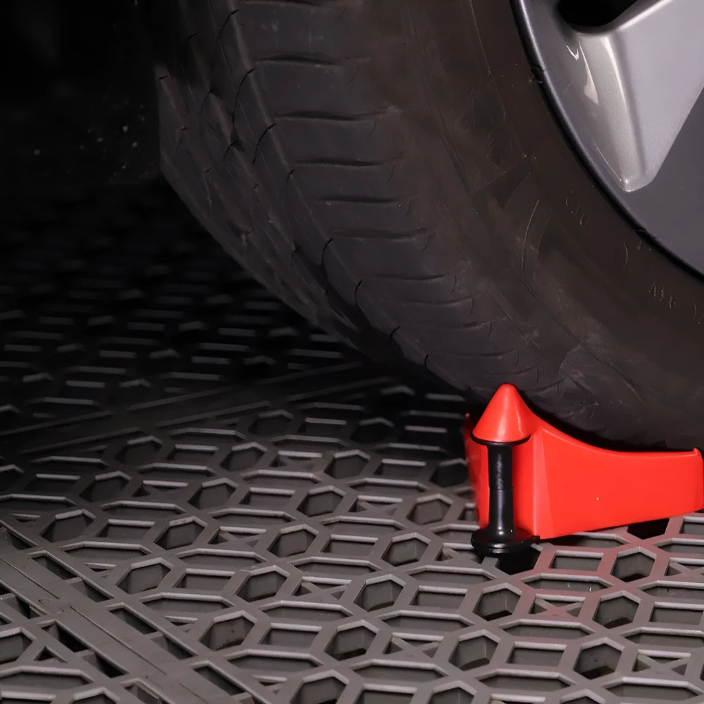 Set of four red triangular plastic car parking blocks or wheel stops on a grey background.