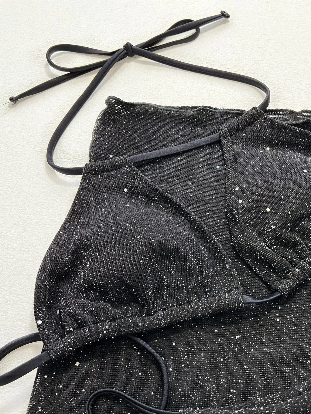 Black women's three-piece bikini swimsuit set with halterneck top and shorts on a mannequin.