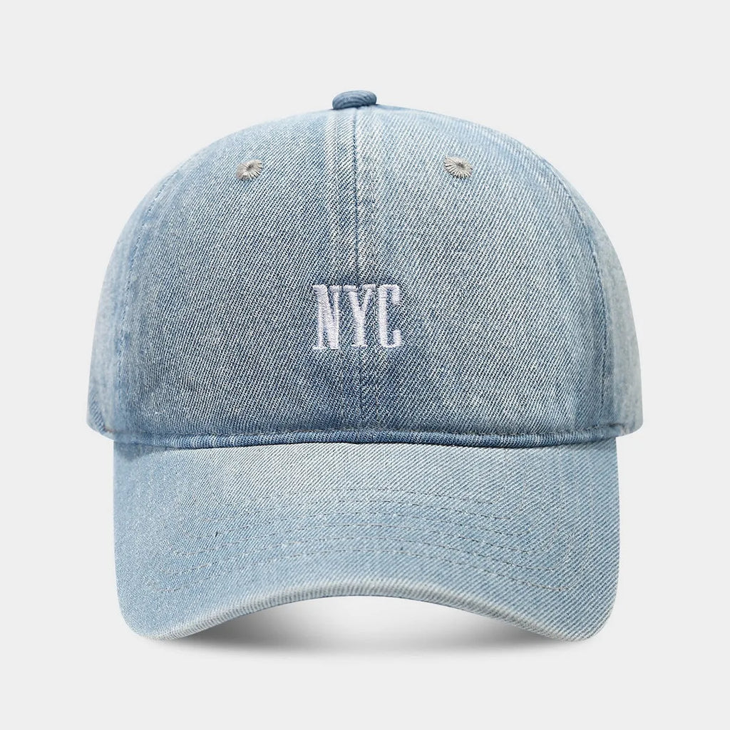Light blue denim peaked cap with embroidered lettering on the front, showing adjustable strap.