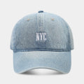 Light blue denim peaked cap with embroidered lettering on the front, showing adjustable strap.