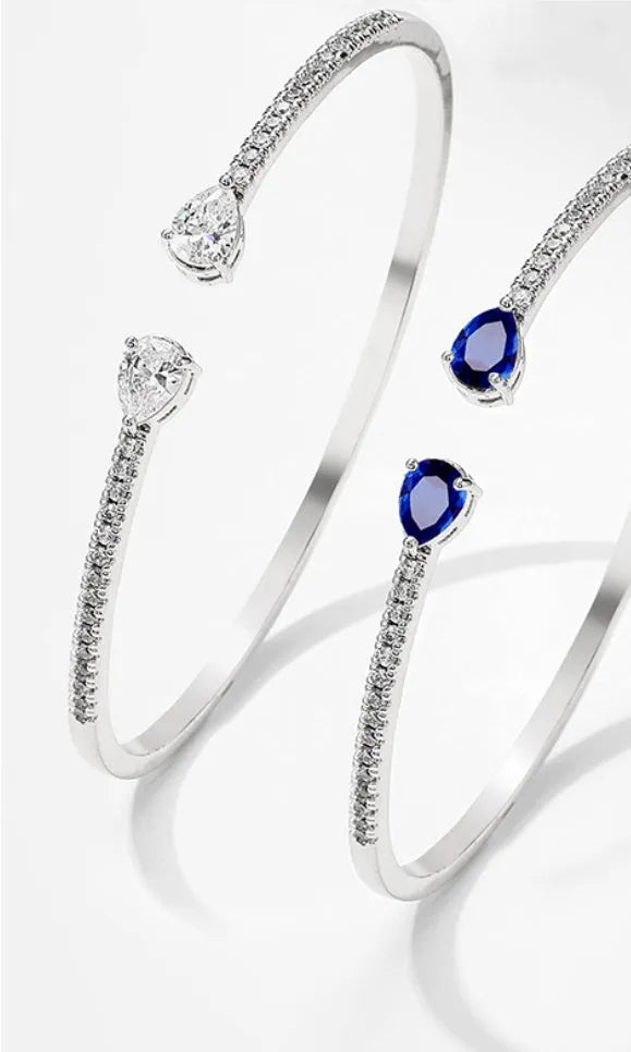 Multi-zircon copper bracelet with zircon inlaid detailing available in white or blue colour