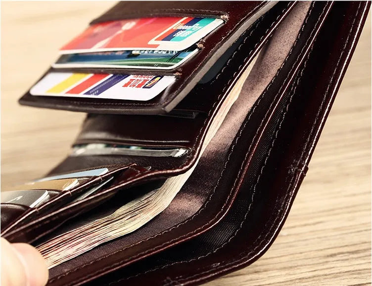 Men's black leather wallet open to show photo window, card slots, coin pocket and banknote folder.