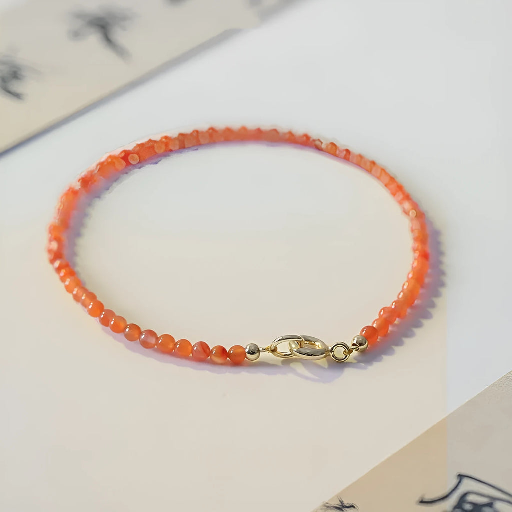 Close-up of a women's retro bracelet with Southern Red agate beads showing 3mm cut surface, in cherry red colour on a wrist.
